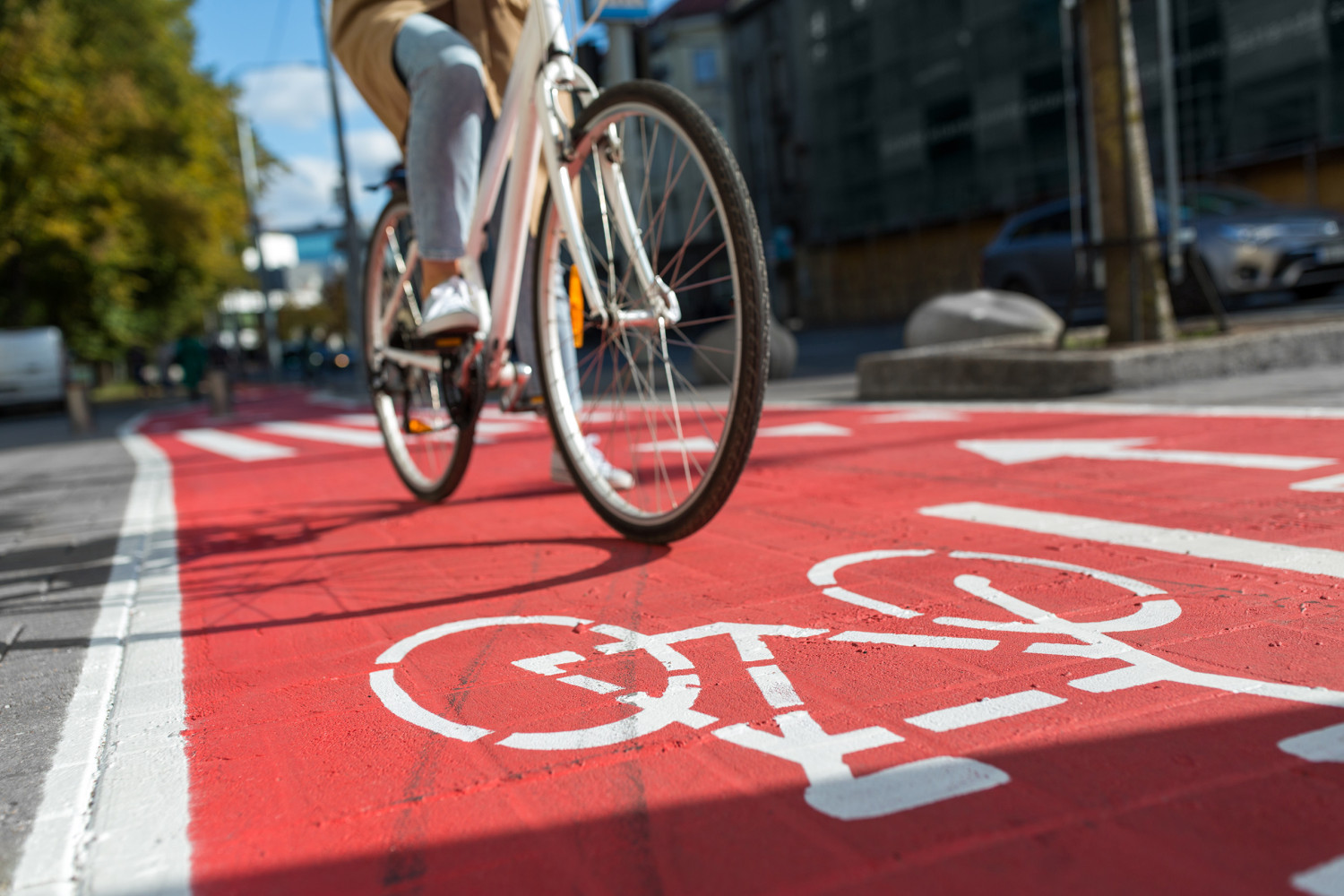 a white bicycle being ridden down a red bike path